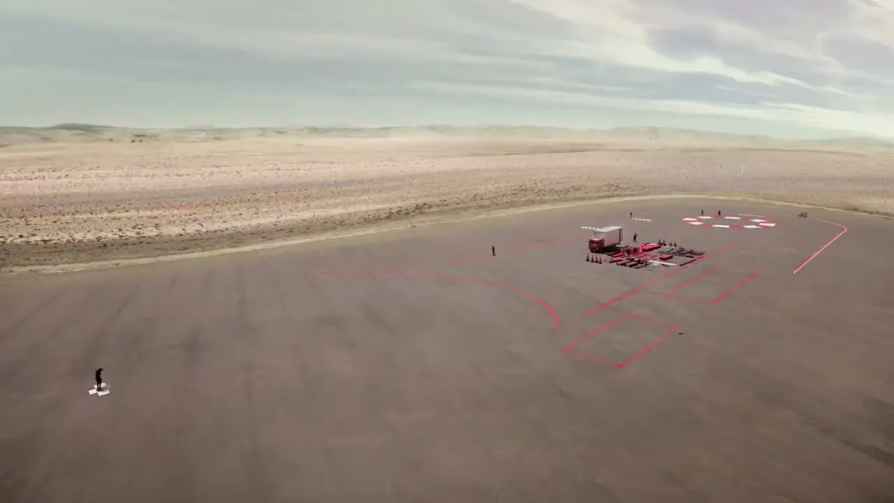 An aerial shot shows a vast desert landscape with a large, empty asphalt area where a small group of people are setting up a temporary race track with red and white markings.