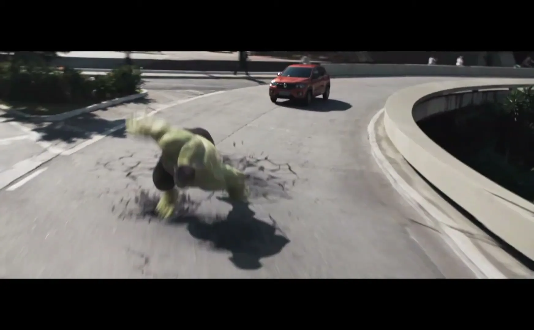 The Hulk, a large green muscular figure, runs on a road as a red car drives in the background.
