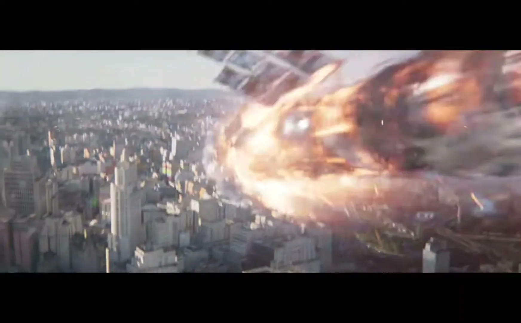 An aerial view of a sprawling city with numerous buildings and a highway, as a fiery, debris-filled object crashes into the cityscape.