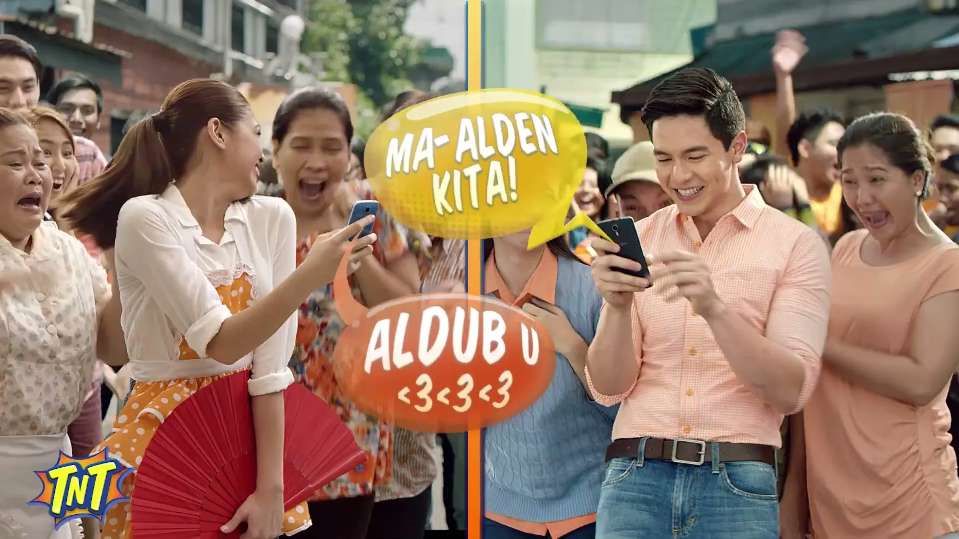 A split screen shows a young woman and a young man, both smiling and looking at their phones, surrounded by a cheering crowd in a bustling outdoor market.