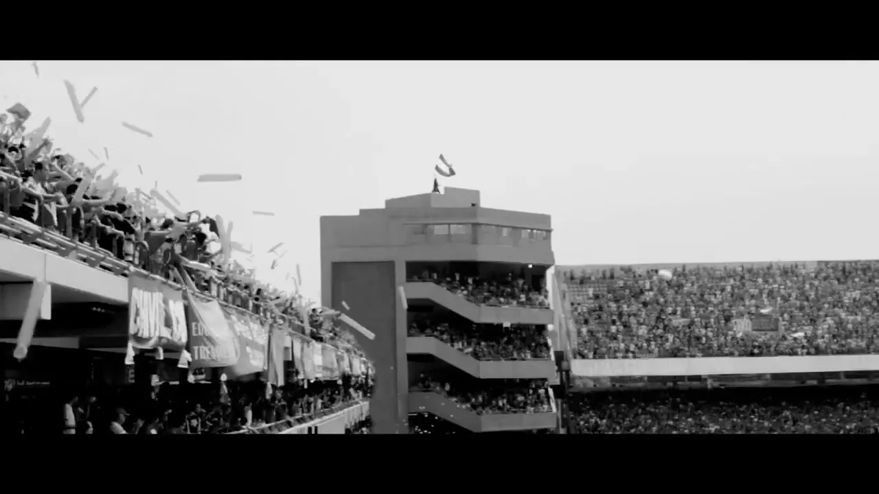 A wide shot of a packed football stadium, with fans cheering and confetti falling, capturing the excitement of a game.