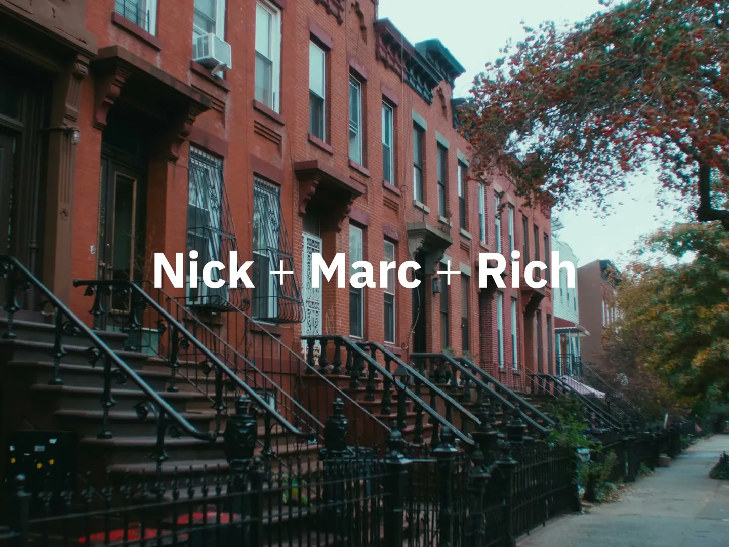 A row of brownstone buildings with front stoops and iron fences line a street, with white text overlaid on the image.