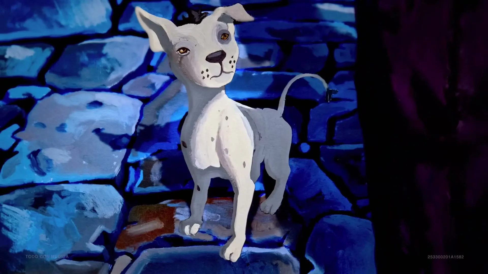 A white dog with black spots and orange eyes stands on blue rocks, looking up with a slight smile.