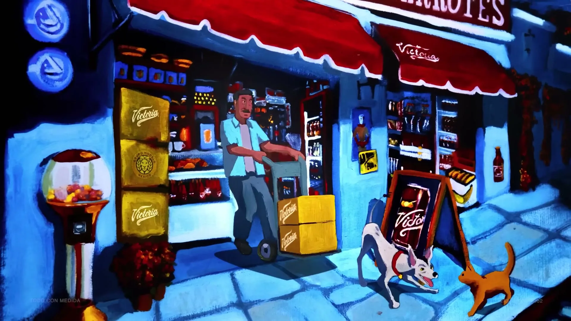 A man pushes a hand truck with boxes outside a store, while a dog and a cat walk past him on the sidewalk at night.