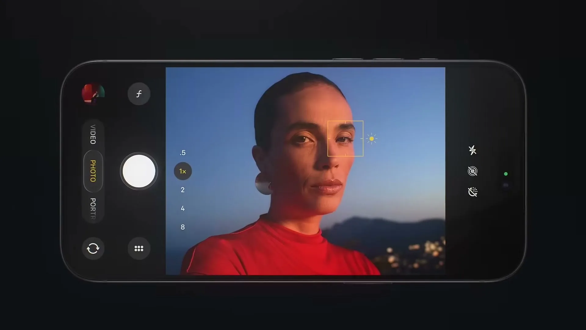A woman in a red shirt is seen on a smartphone screen, with the camera app interface visible, as the phone adjusts focus and exposure.