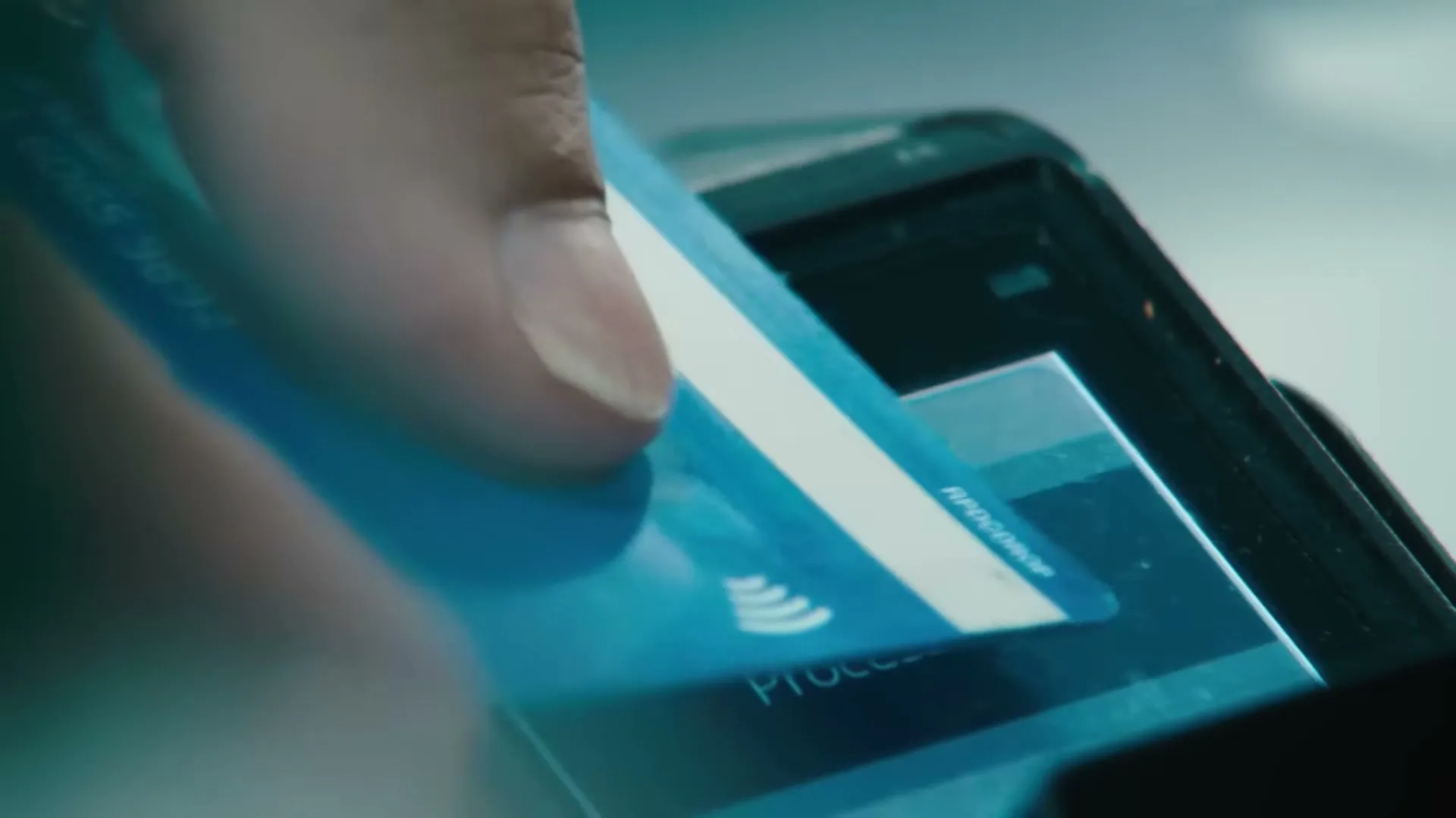 A person's hand inserts a blue credit card into a payment terminal, displaying "CREDIT Sale" and "$1.04" on its screen.