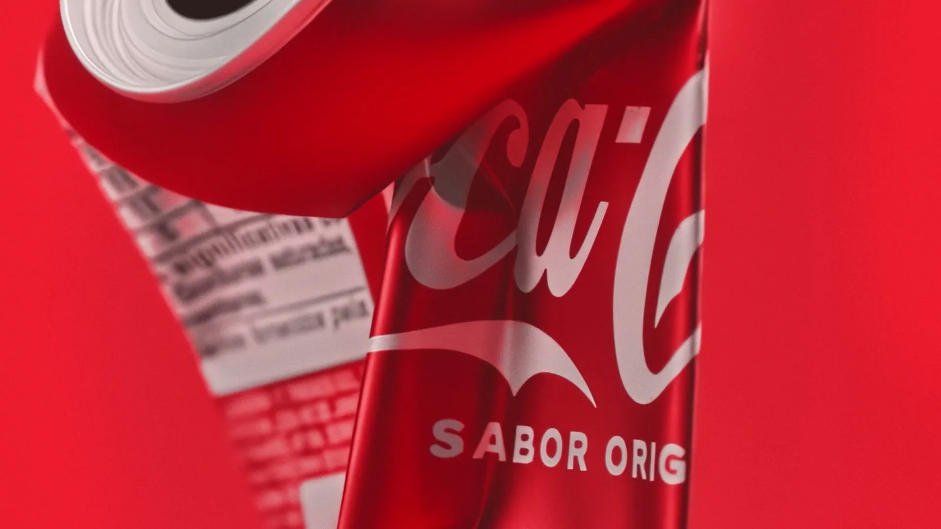 A close-up shot of a red Coca-Cola can, with the brand's logo and "SABOR ORIG" visible, against a red background.