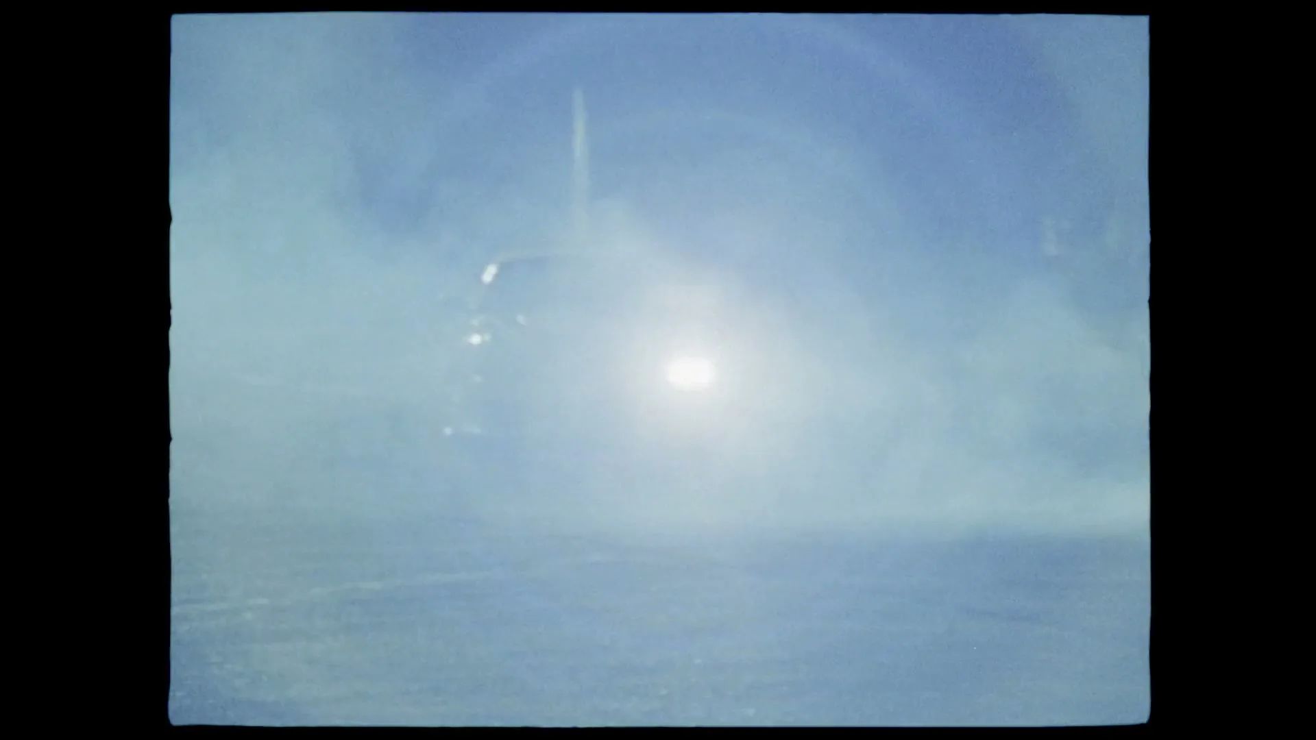 Two cars drift in a smoky, dark parking lot at night, with headlights and taillights glowing through the haze.