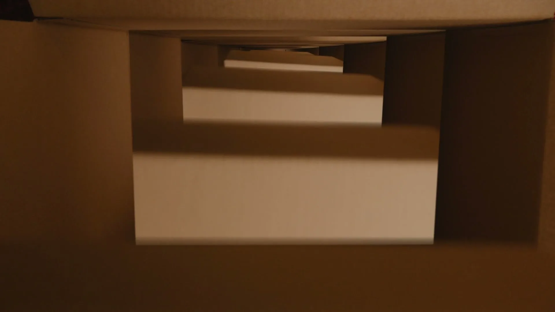 A camera moves through a series of nested cardboard boxes, revealing the eBay logo on tape as the final box is placed inside.