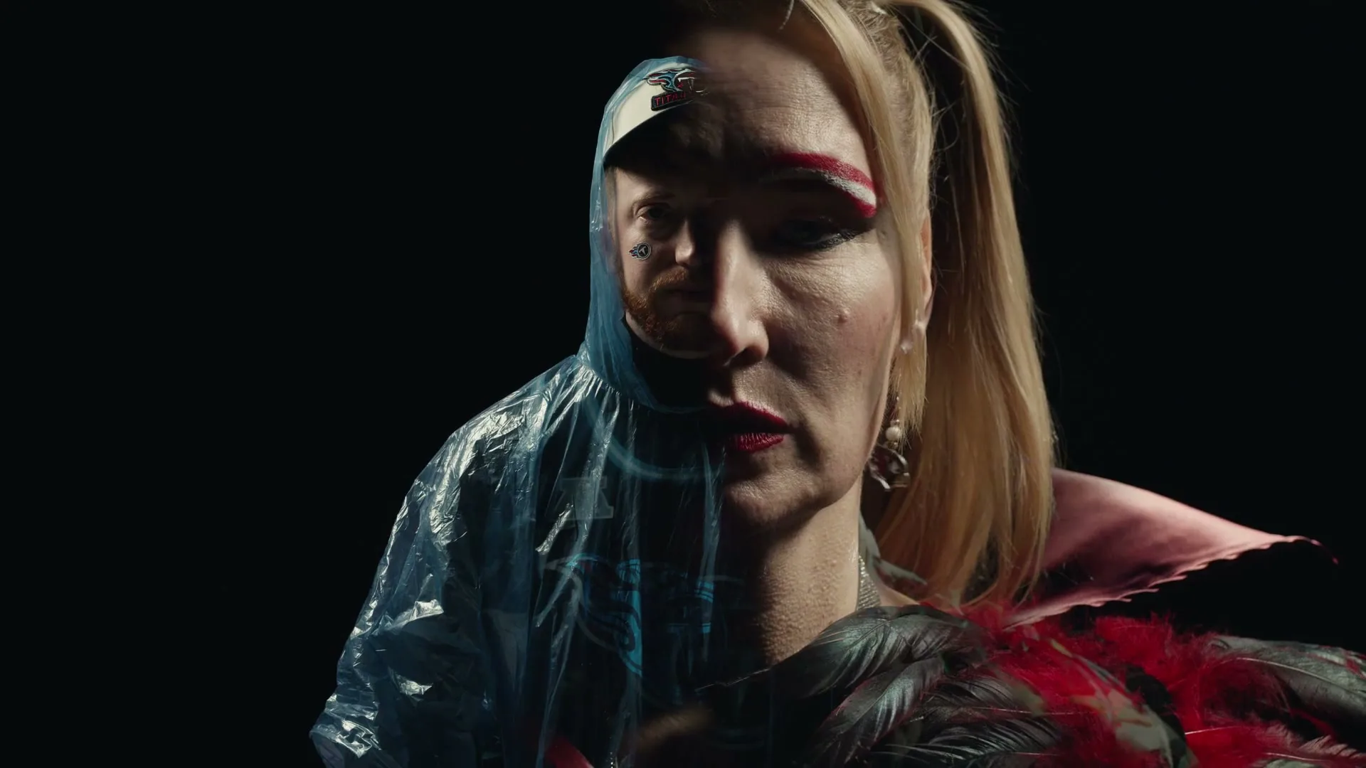 A person with a split face, half male and half female, looks directly at the camera in a studio void.