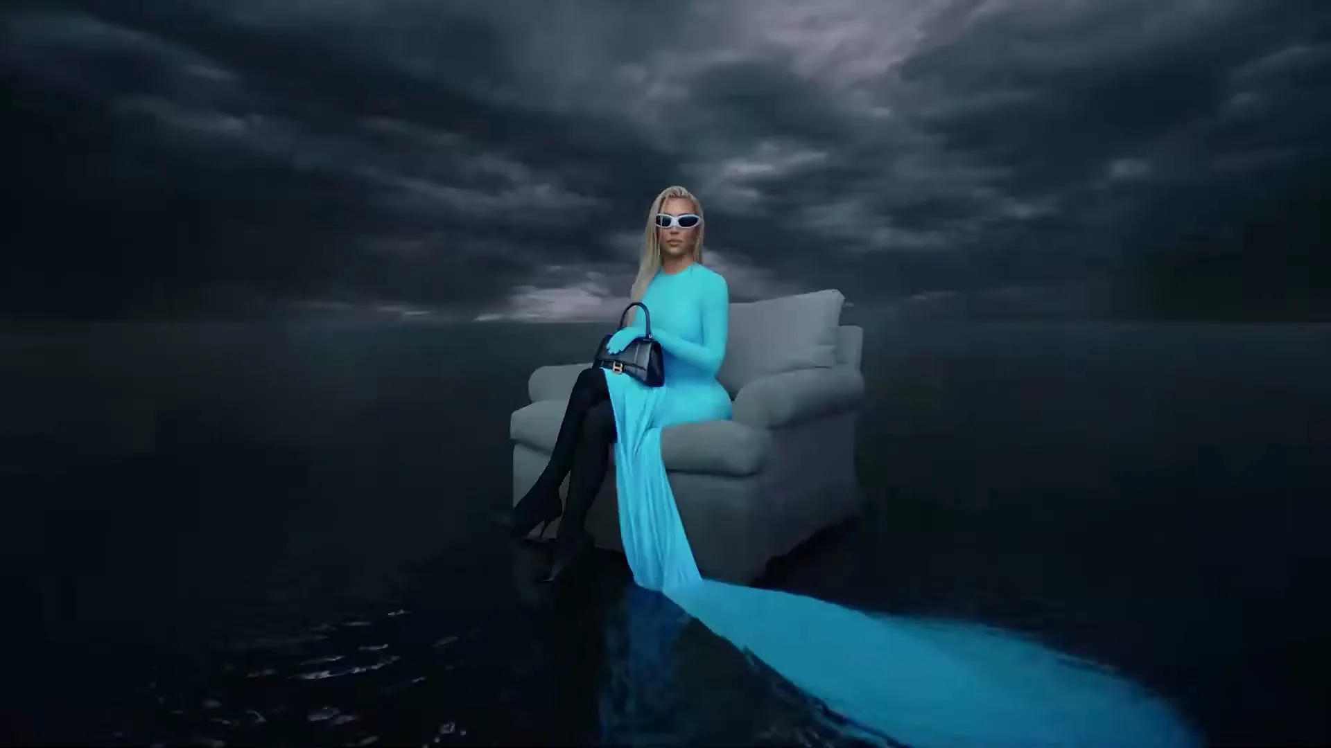 Kim Kardashian sits on a couch in a flooded, stormy landscape, wearing a long blue dress, sunglasses, and holding a black handbag.