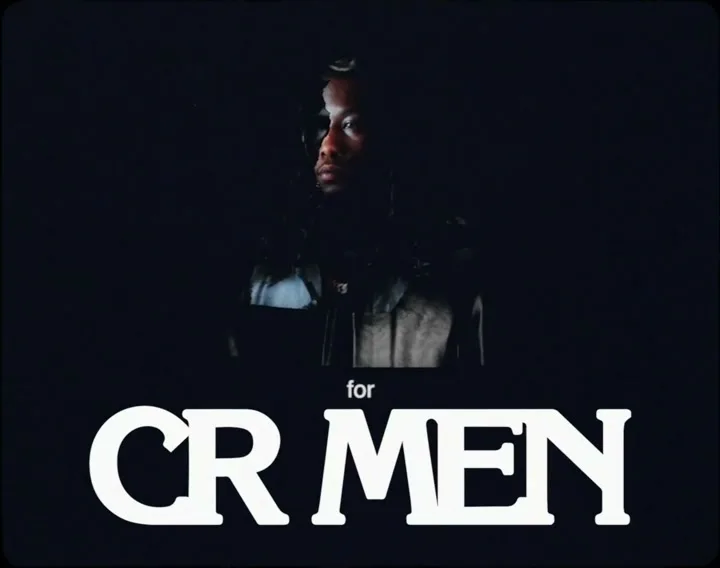 A man with dreadlocks looks to the side, illuminated by a single light source, with the text "for CR MEN" below him on a black background.