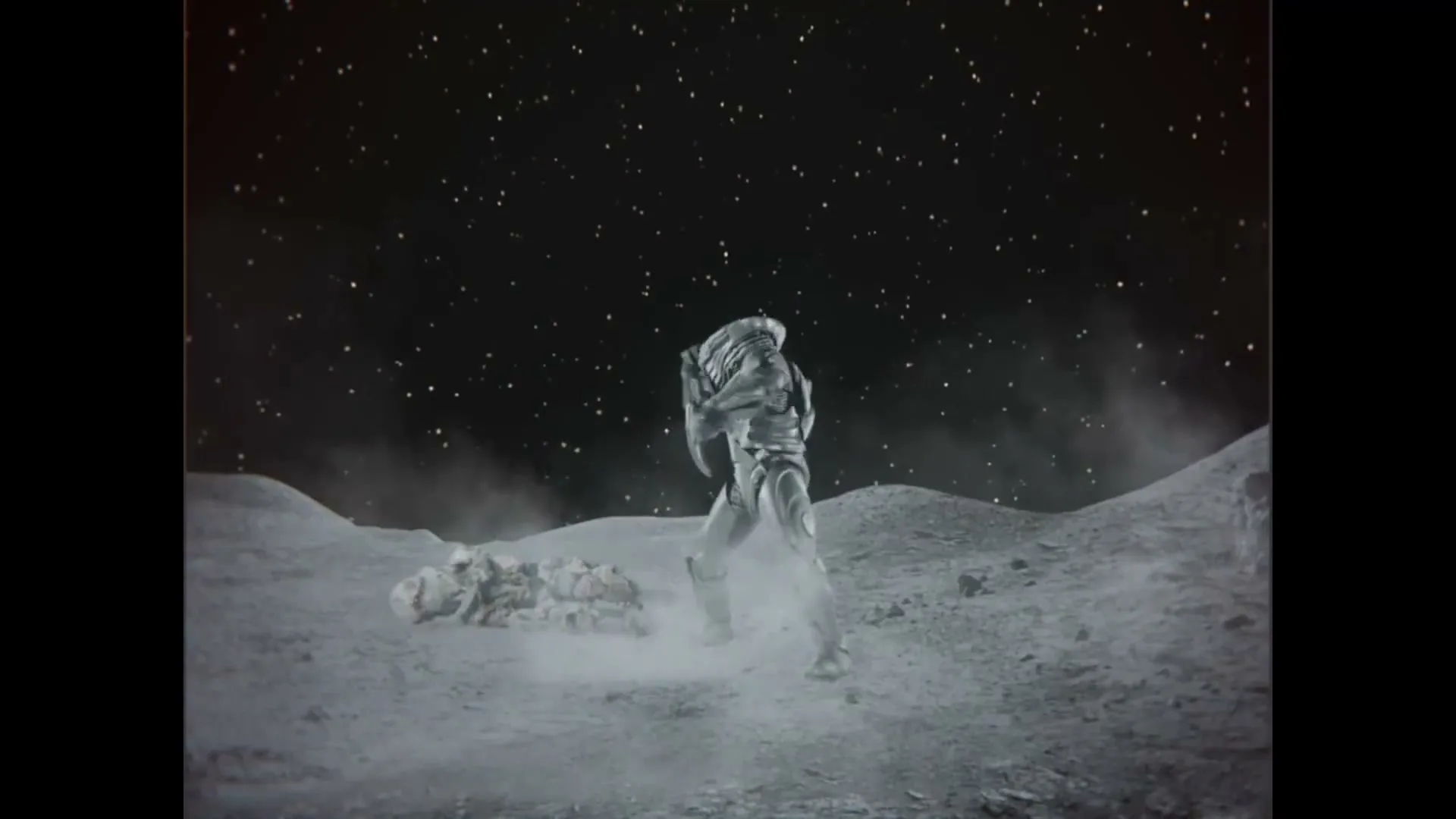 Two astronauts in bulky suits fight on the moon's surface, one knocking the other down, under a starry night sky.