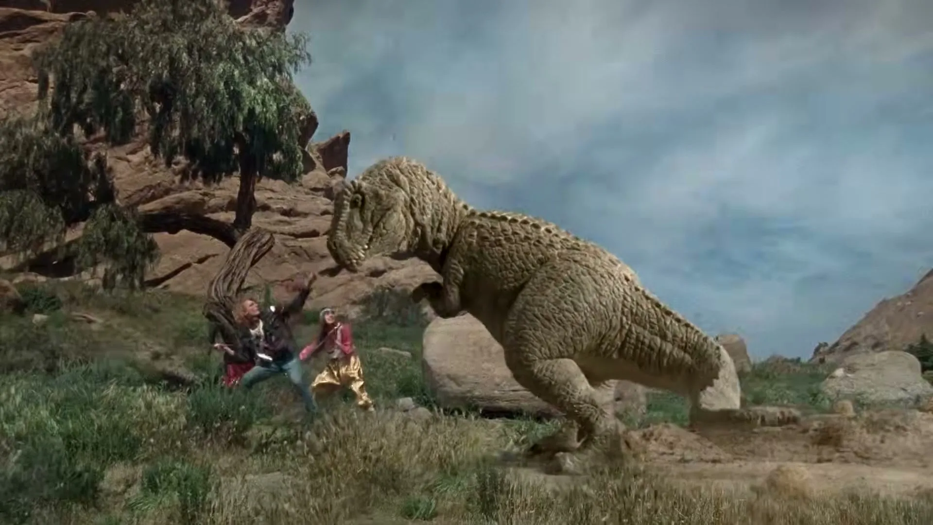 Two people in retro-futuristic outfits run from a large dinosaur in a rocky, arid landscape under a cloudy sky.