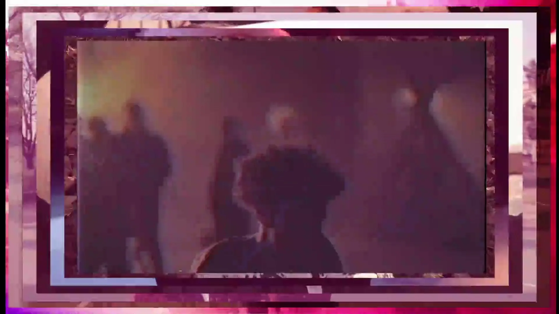 A young person with curly hair dances in a dimly lit, smoky room with other blurred figures in the background, creating a dynamic and energetic scene.