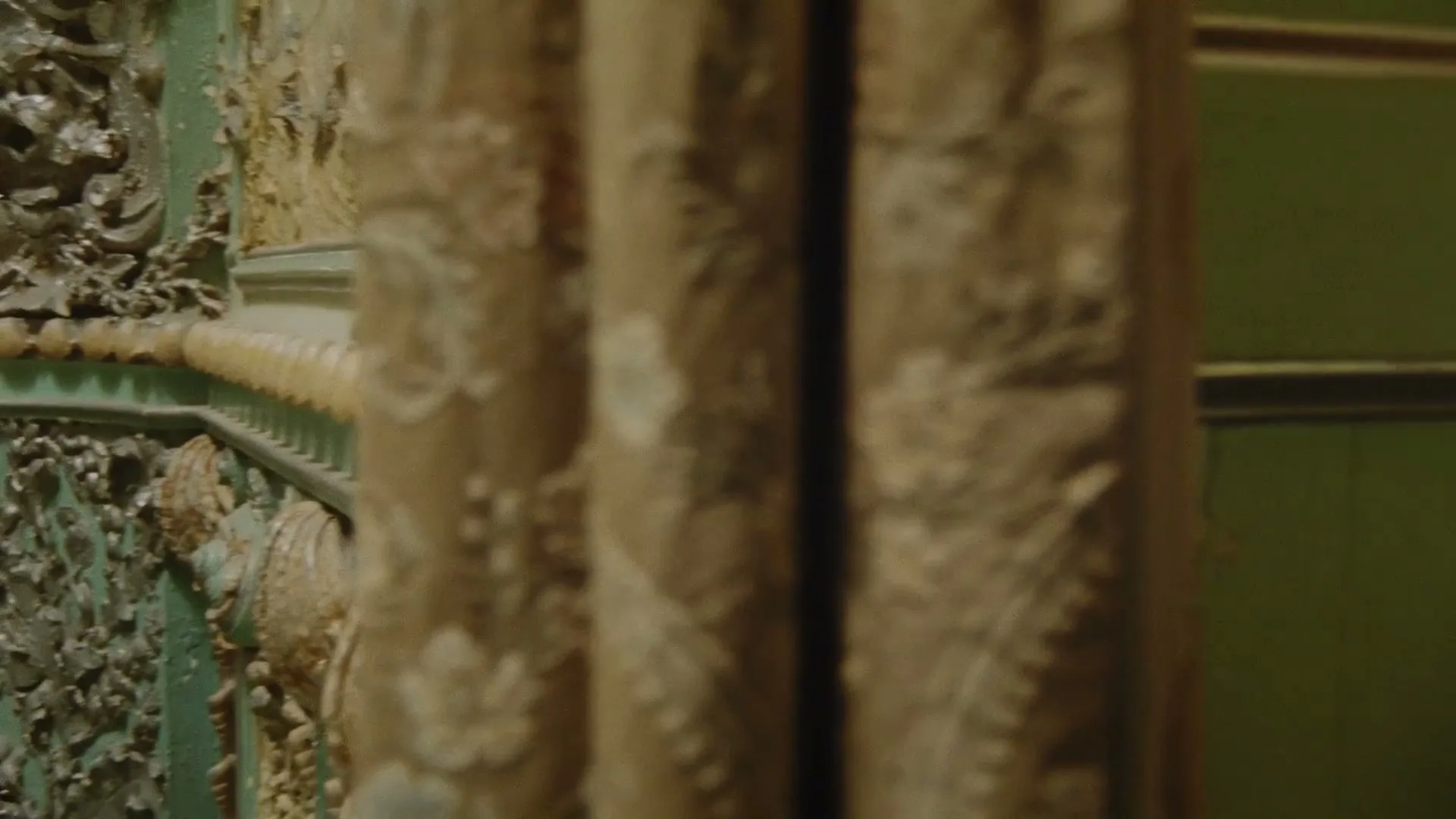 A slow pan reveals a highly ornate, antique dressing table adorned with various decorative objects, including perfume bottles, statues, and a lamp, in a lavish room.