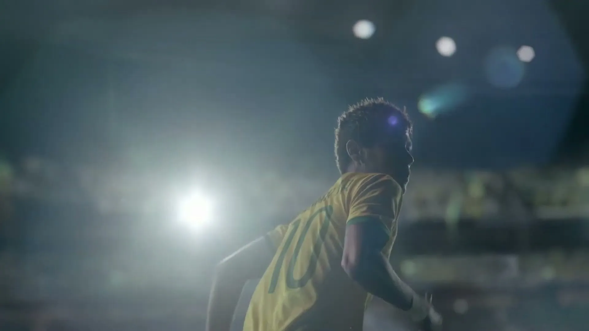 Neymar Jr. in a yellow soccer jersey with number 10, runs across a stadium field at night, with bright stadium lights in the background.