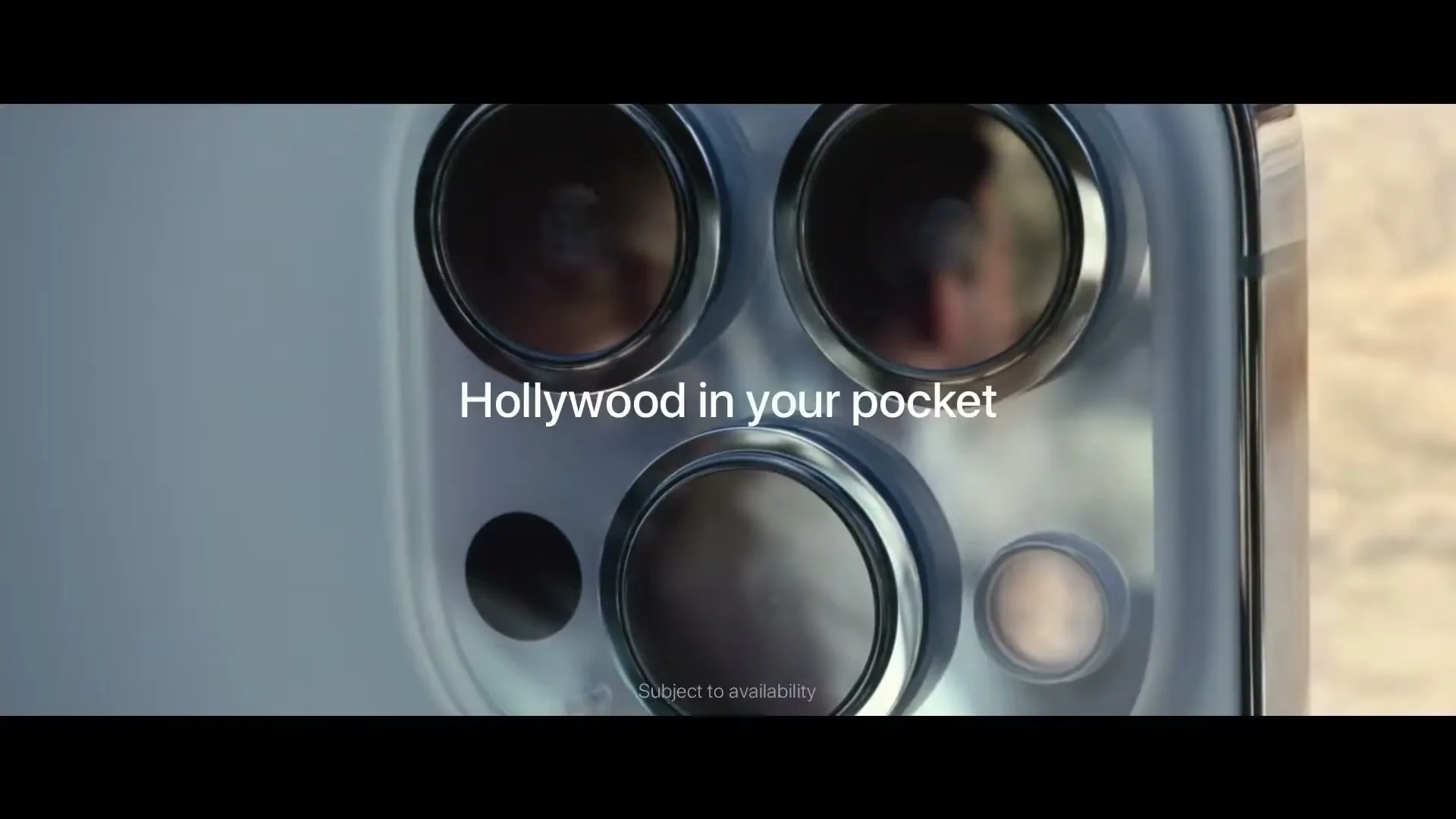 A close-up shot of the back of a silver iPhone 13 Pro, highlighting its three camera lenses, with text overlays appearing and changing.