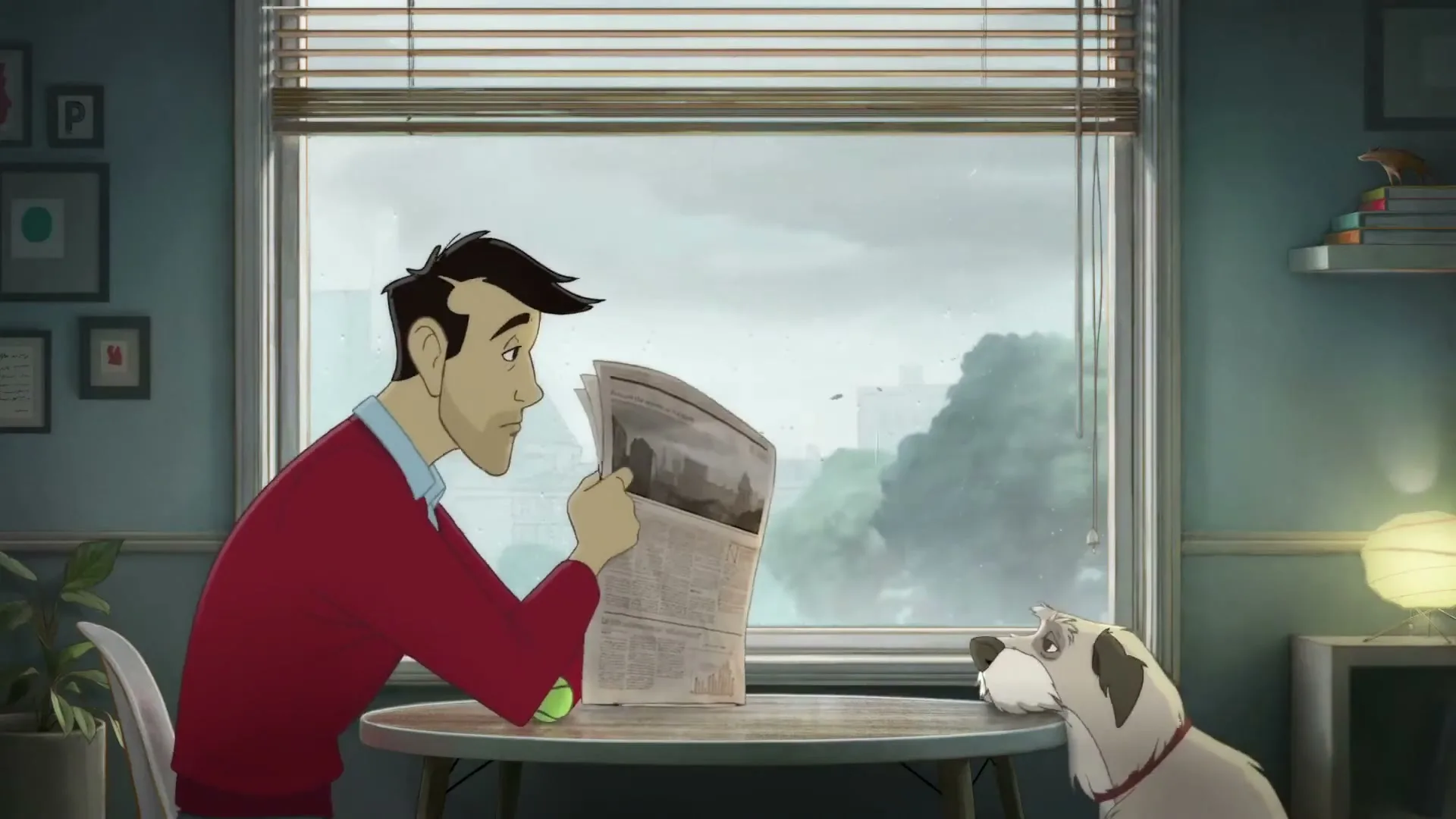 A man in a red sweater sits at a table reading a newspaper, while his dog tries to get his attention with a tennis ball on a rainy day indoors.