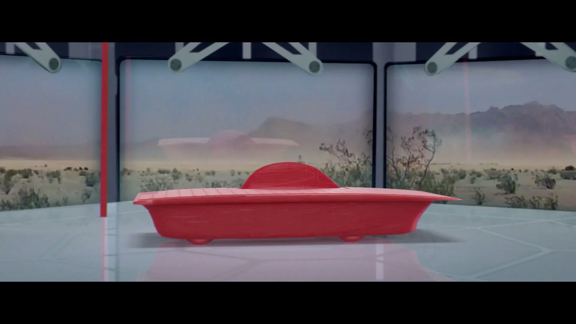 A red, stylized car and two red figures stand on a reflective surface in a futuristic room, with desert landscapes displayed on screens behind them. The scene transitions to a red figure in a car seat floating above Earth.