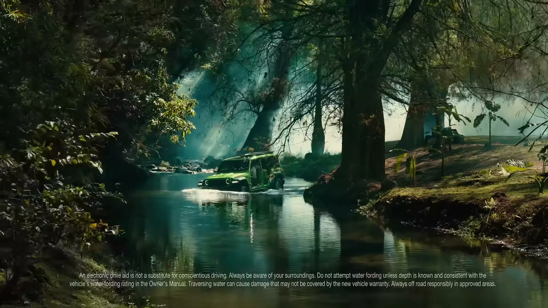 A green Jeep Wrangler drives through a shallow river in a lush, sun-dappled jungle, with rays of light filtering through the trees.