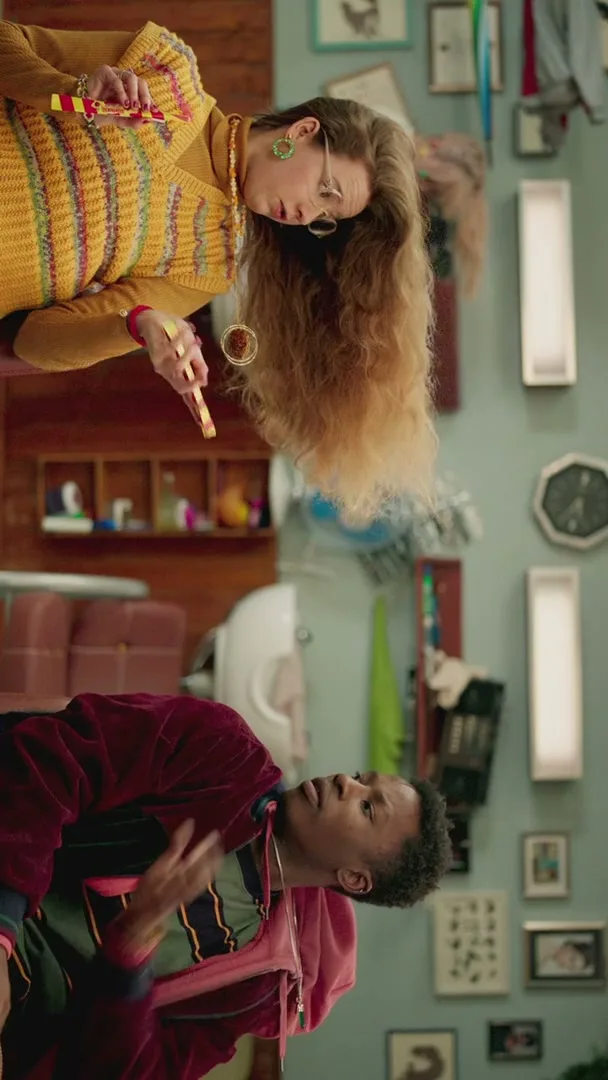 A young man and an older woman are upside down in a salon, looking at each other, as the woman holds a Starburst Swirler.
