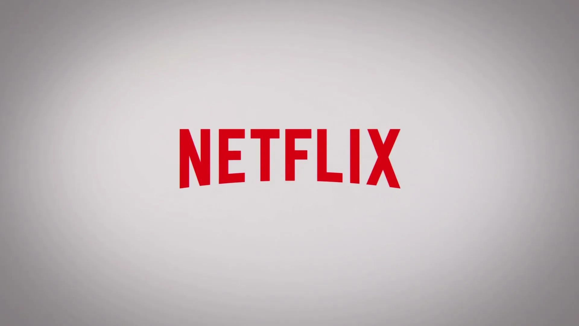 The Netflix logo appears on a white background, then fades to reveal a woman in an orange jumpsuit holding a blanket in a prison setting.
