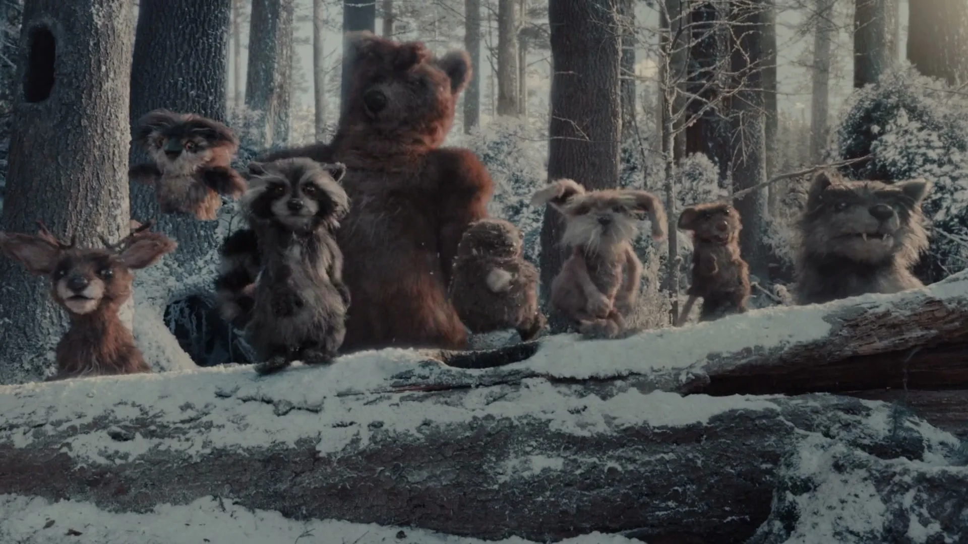 A group of diverse, furry forest animals, including a bear, raccoon, and deer, stand on a snow-covered log in a winter forest, looking around curiously.