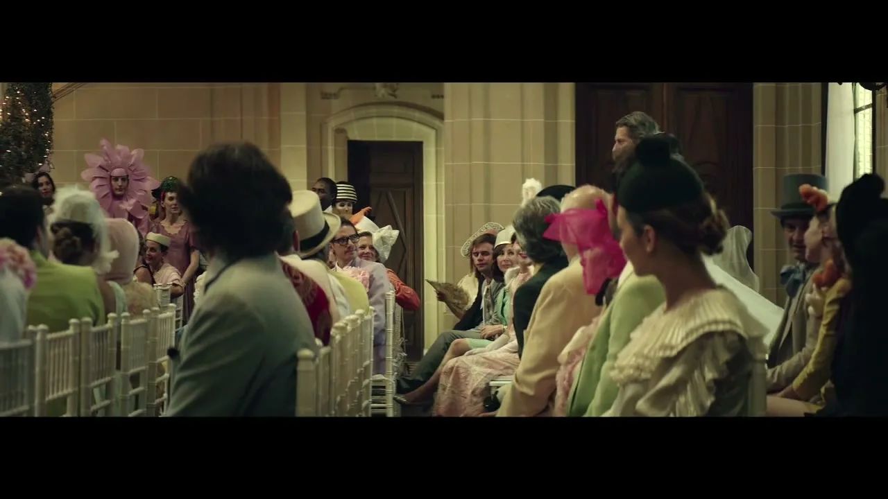 A diverse group of wedding guests, dressed in colorful and eccentric attire, are seated in a church, watching the ceremony unfold.