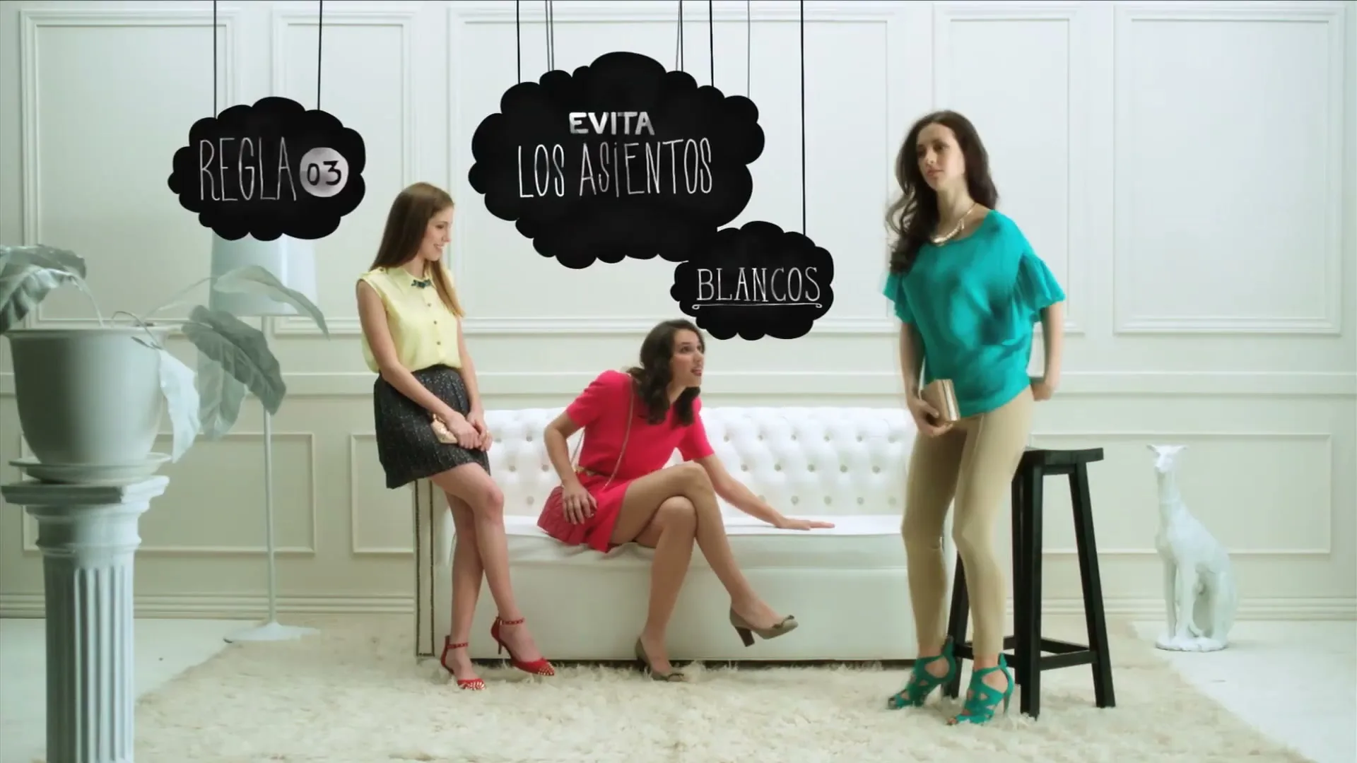 Three young women in stylish outfits are in a white room, one sitting on a couch, one leaning on it, and one standing next to a stool, as text appears above them.