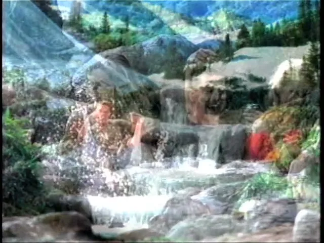A group of young adults, including a man and two women, are seen from the chest up, laughing and splashing in a hot tub, with a Coors Light can visible.