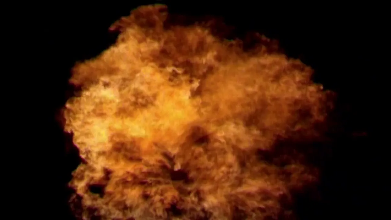 A fiery explosion erupts from the bottom of the frame, expanding rapidly against a dark, void-like background.