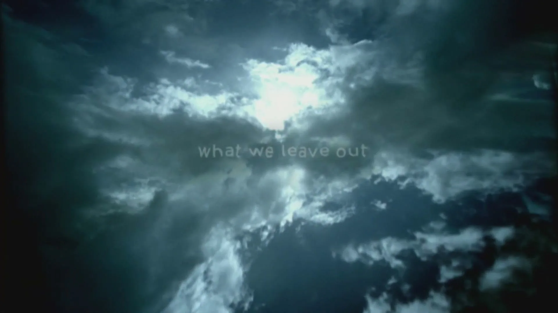 Text appears on screen, "but also what we leave out", against a backdrop of dark, dramatic clouds with a bright light shining through.