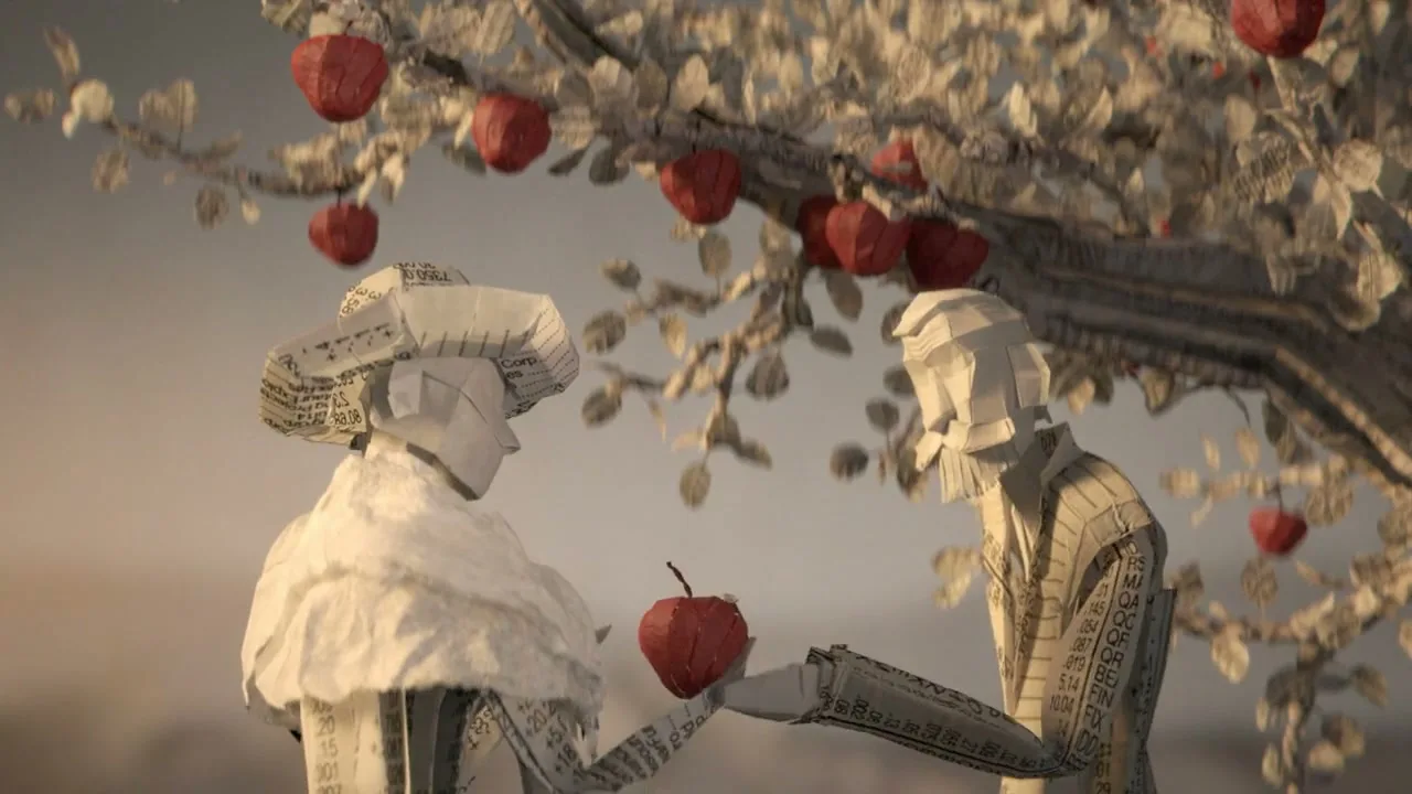Two paper figures, a man and a woman, stand under a paper tree with red apples, as the man offers an apple to the woman in a stop-motion animation.