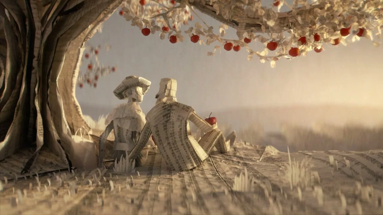 Two paper figures, a man and a woman, sit under a paper apple tree with red apples, looking out at a hazy horizon.