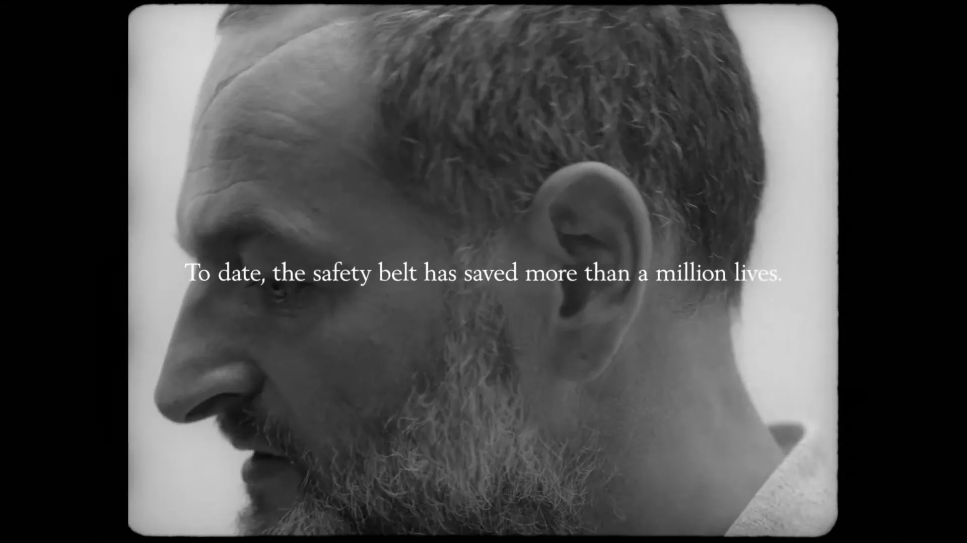 A man with a beard is shown in profile, looking down and to the left, with text on screen about the safety belt.