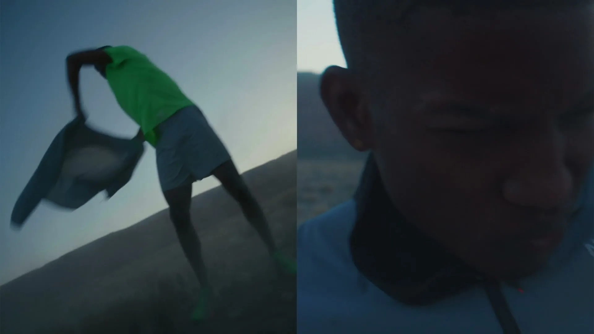 A young man in athletic wear struggles to put on a jacket in a windy, desolate landscape at dusk, with a close-up on his face and the jacket's logo.