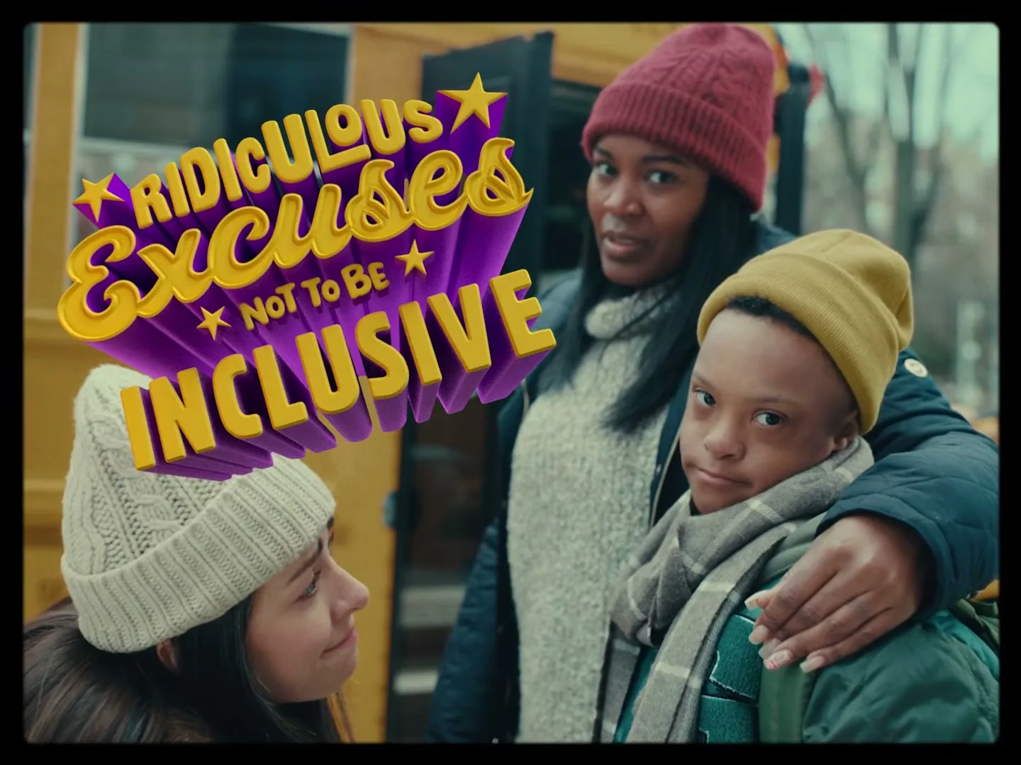 A young woman, a boy with Down syndrome, and a woman stand together outside a yellow school bus, looking at the camera with a serious expression.