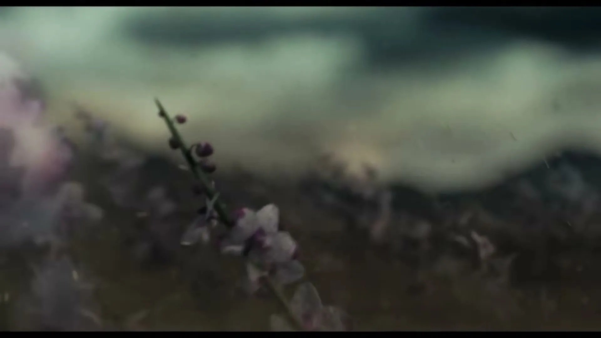 A close-up shot of a delicate purple flower stem, with a blurred background of dark clouds, as it sways gently in the wind.