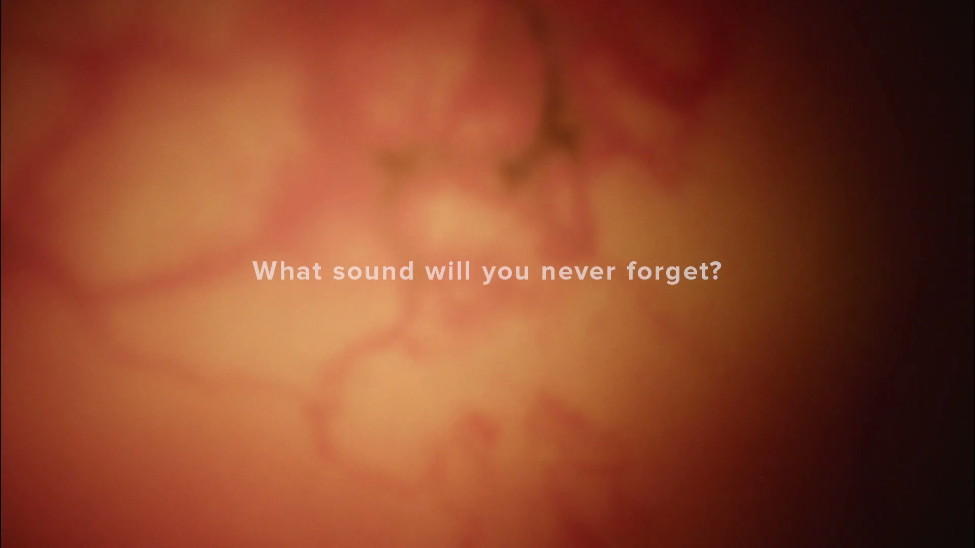 On a blurry, abstract background of warm orange and red tones, white text asks, "What sound will you never forget?"