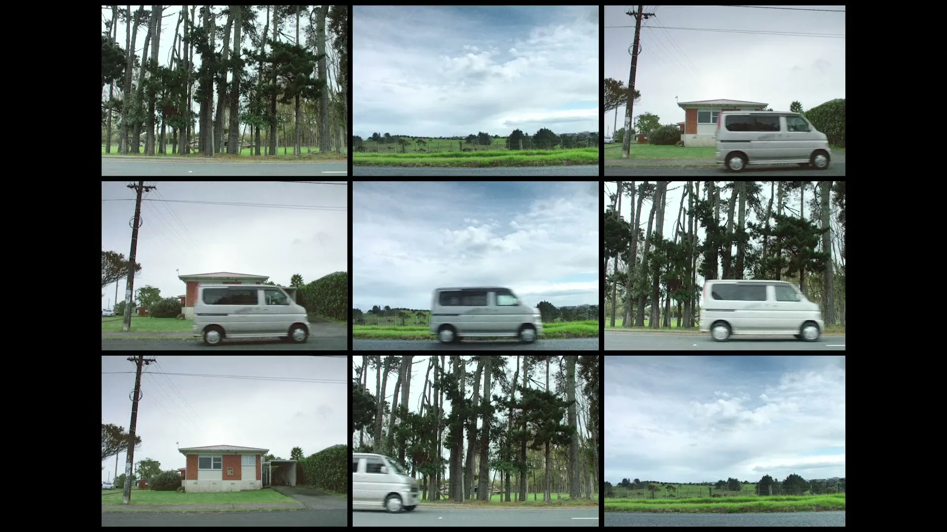 A white van drives past a small house and a line of tall trees on a cloudy day in a rural setting.