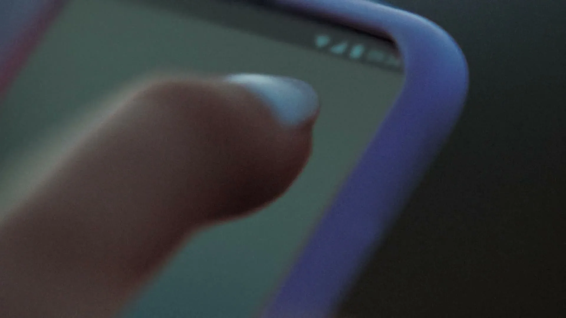 A person's finger taps on a smartphone screen, showing a green app icon, in a close-up shot.