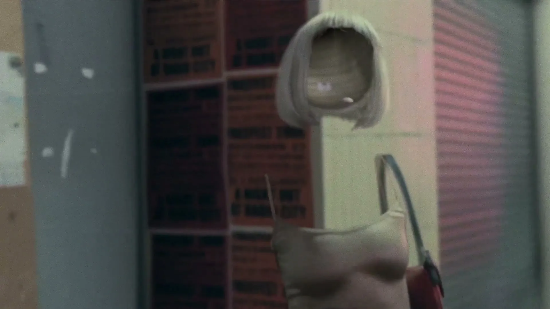 An invisible woman, wearing a blonde wig, beige top, and red purse, walks down a city street at night.