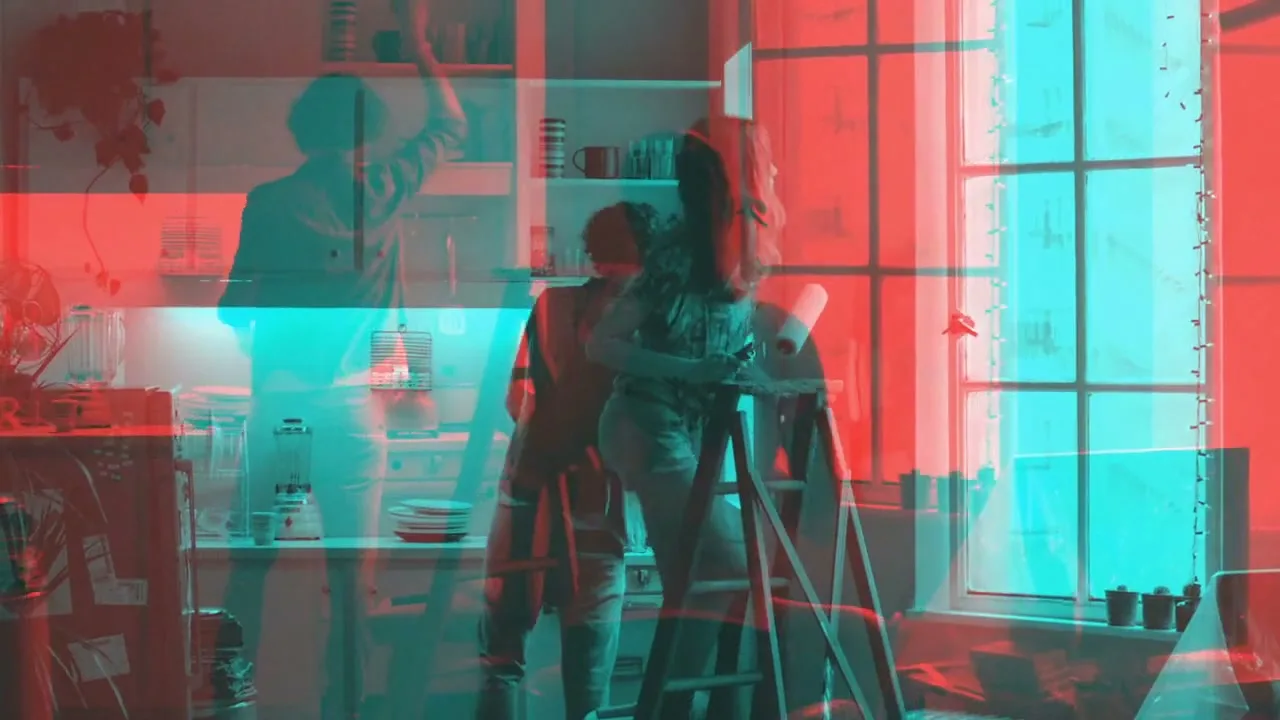 A young woman on a ladder and a young man are in a kitchen, with a red and cyan color overlay, as if viewed through 3D glasses.