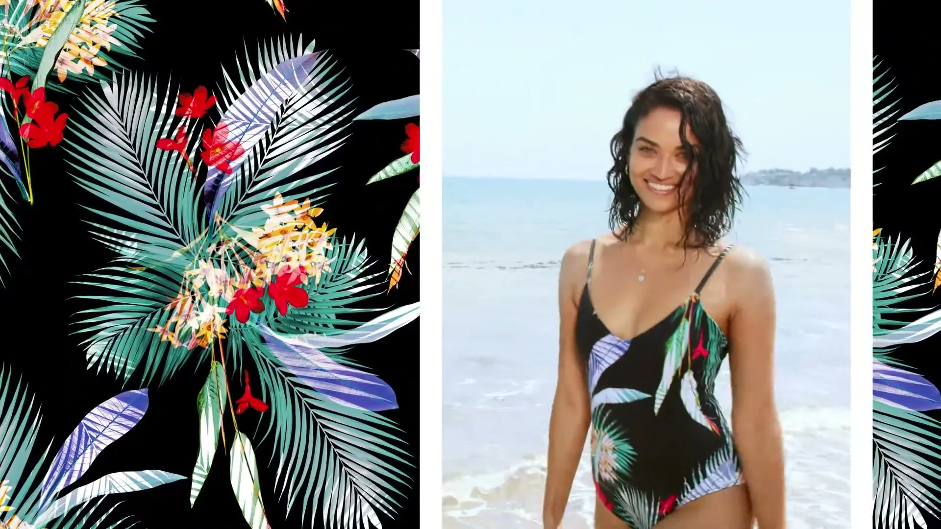 A young woman with dark, wet hair, wearing a black, tropical-print swimsuit, walks out of the ocean onto a sandy beach, smiling at the camera.
