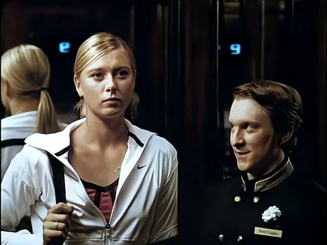 Maria Sharapova, a blonde woman in a white Nike jacket, stands next to a male bellhop in an elevator, looking straight ahead.