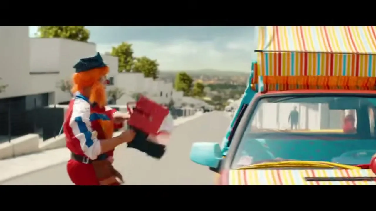 Two clowns, one with orange hair and a red suit, the other with blue hair and a striped shirt, run towards a colorful car on a suburban street.