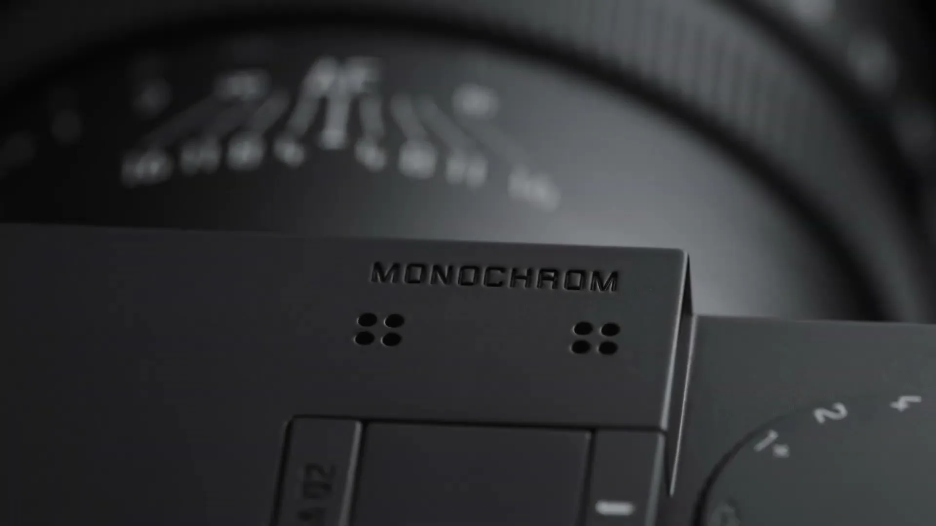 A close-up shot of a black Leica Monochrom camera, with the word "MONOCHROM" visible on its top plate.