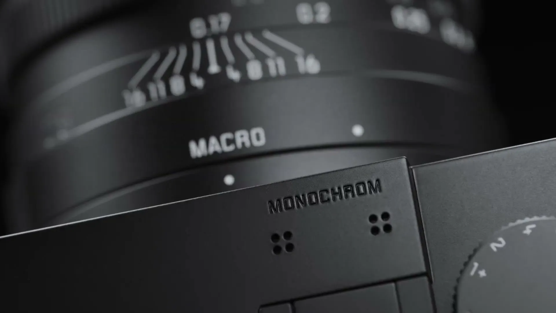 A close-up shot of a black Leica camera lens and body, with "MACRO" and "MONOCHROM" text visible on the camera.