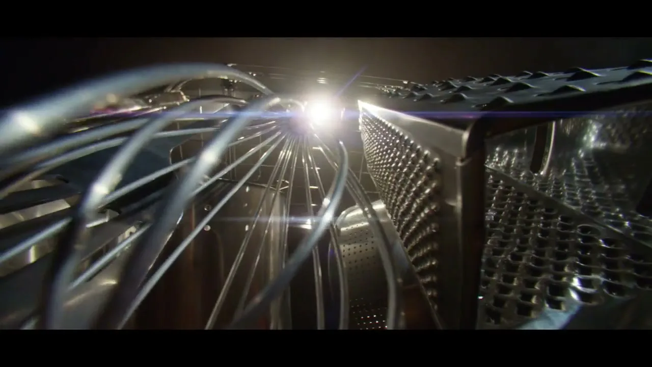 A close-up shot of a metal whisk and a cheese grater, with a bright light source in the background.